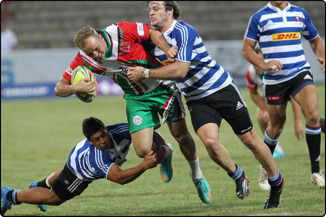 Rugby player wearing a white-blue and white-red striped jersey running towards the try line